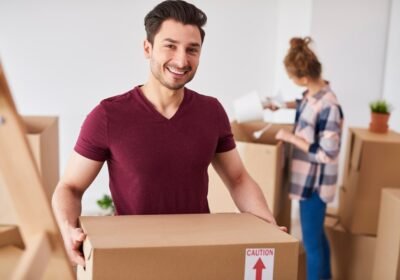 smiling-man-moving-into-new-home-unpacking-his-stuff_329181-19943